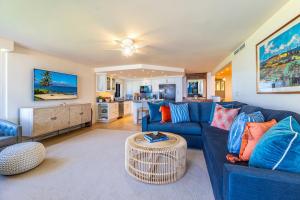 a living room with a blue couch and a table at Polo Beach Club 106 condo in Wailea