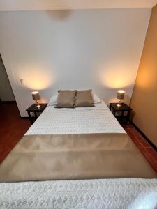 łóżko w pokoju z dwoma stolikami bocznymi w obiekcie Siwõ Art Guesthouse w mieście Ocotal