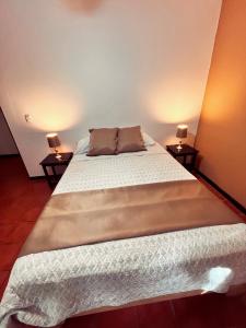 Siwõ Art Guesthouse في Ocotal: غرفة نوم بسرير كبير مع مواقف ليلتين