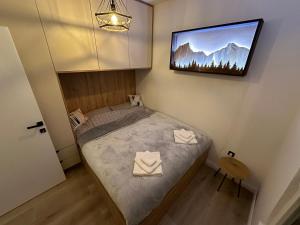 ヤホリナにあるSunset Pines Apt, Villa Montの壁にテレビが付いたベッドのある寝室