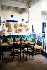 a room with a table and chairs and a couch at MED APPARTEMENT in Essaouira