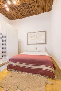 a bedroom with a large bed with a rug at MED APPARTEMENT in Essaouira