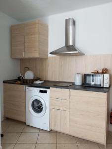 a kitchen with a washing machine and a microwave at Apartamento Te Miti in Puerto del Carmen