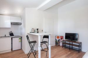 a small kitchen with a table and two chairs at Lumignons Lyonnais - Doua in Villeurbanne