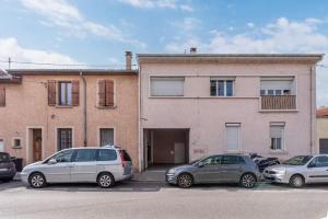 a group of cars parked in a parking lot in front of a building at Lumignons Lyonnais - Doua in Villeurbanne