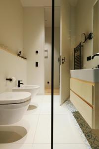 a bathroom with two sinks and a toilet at Mr(s)STiL Design Apartments in Berlin