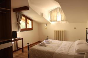 1 dormitorio con cama blanca y escritorio en Hotel Al Verde en Mandello del Lario