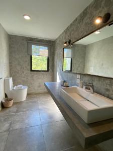 uma casa de banho com um lavatório, uma banheira e um espelho. em Panacea Condo Tulum em Tulum