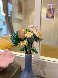 eine blaue Vase mit Blumenmodellen darin in der Unterkunft La Galerie Dinard in Dinard