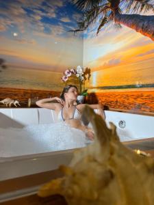 Una donna seduta in una vasca da bagno sulla spiaggia di Dream & Relax Villa Fiore a Bari