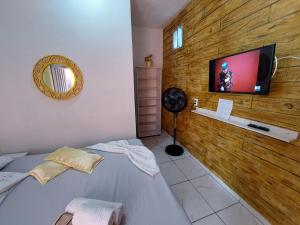 um quarto com uma cama e uma televisão de ecrã plano em Guest House Palmeiras em Cabo Frio