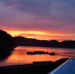 zachód słońca nad jeziorem z łodziami w wodzie w obiekcie L57_resort w mieście Gródek Nad Dunajcem