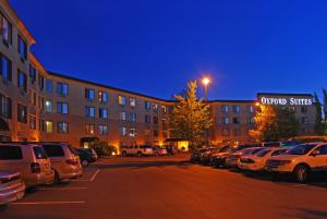 un estacionamiento con autos estacionados frente a un edificio en Oxford Suites Portland - Jantzen Beach, en Portland