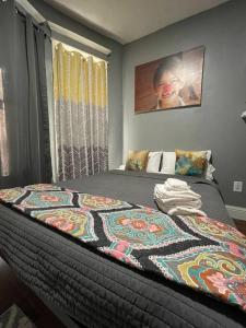 a bed with a colorful blanket on it in a bedroom at Cozy Luxury Studio Staycation - Brooklyn close to Train in Brooklyn