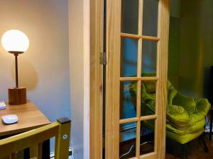 a glass door with a green chair in a room at Cozy Luxury Studio Staycation - Brooklyn close to Train in Brooklyn