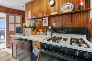 a kitchen with a stove and a counter top at Pinehurst Sunset Beach Cottage in Wareham +26 photos
