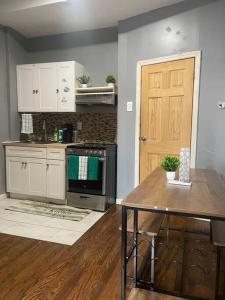 a kitchen with a stove and a table and a door at Cozy Luxury Studio Staycation - Brooklyn close to Train in Brooklyn