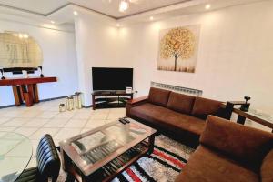 a living room with a couch and a flat screen tv at F2 haut-standing akid lotfi in Oran