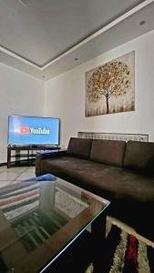a living room with a couch and a tv at F2 haut-standing akid lotfi in Oran