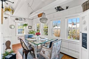 a dining room with a table and chairs and windows at 227 Winter St, Hyannis in Barnstable