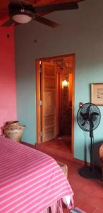 1 dormitorio con 1 cama y ventilador junto a una puerta en Posada de la Cruz, en Querétaro