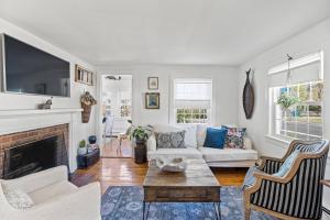 a living room with a white couch and a fireplace at Cottage Serenity Haven in Barnstable