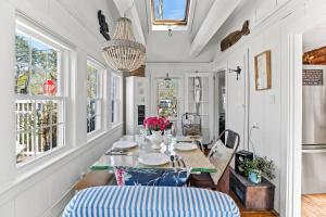 a dining room with a table and chairs and windows at Cottage Serenity Haven in Barnstable +42 photos