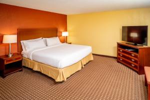a hotel room with a large bed and a television at Holiday Inn Express and Suites Hazard, an IHG Hotel in Hazard