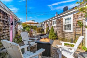 a patio with white chairs and a fire pit at 227 Winter St, Hyannis in Barnstable
