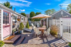 a patio with a table and chairs and an umbrella at Cottage Serenity Haven in Barnstable