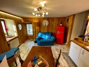 a living room with a table and a red refrigerator at maison la chapelle in Aosta