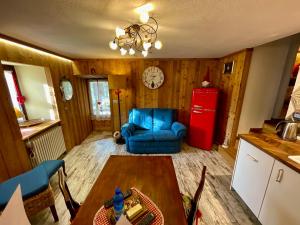 a living room with a table and a red refrigerator at maison la chapelle in Aosta +5 photos