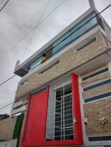 a house with a red door on top of it at Casa Vázquez , "Como en casa" , hospédate con nosotros y recibirás una atención personalizada, servicio y confort nos distingue. in Pachuca de Soto