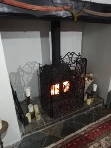 a fireplace with a fire in it with candles at Michaelmas Cottage Upavon in Upavon
