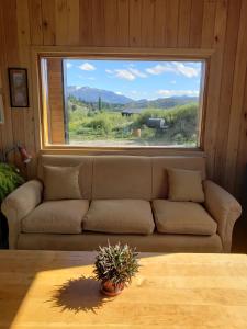 a living room with a couch and a large window at Casa Amapola in San Martín de los Andes