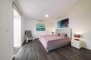 a bedroom with a bed and a chair at Lombo do Doutor Cottage 2 in Calheta