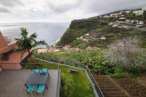 a view of the ocean from the balcony of a house at Lombo do Doutor Cottage 2 in Calheta
