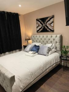 a bedroom with a large white bed with blue pillows at Crestfield Lodge in Thamesmead