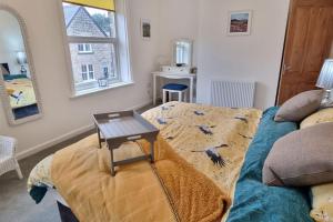 una habitación con una cama con una mesa encima en Dale Cottage Cozy 3 Bedroom nr Ilkley - West Yorkshire en Burley in Wharfedale