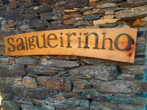 a sign on the side of a stone wall at Casa do Salgueirinho in Casal do Rei