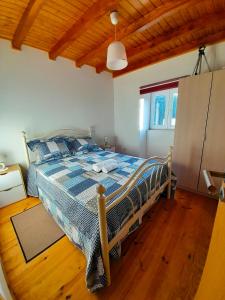 a bedroom with a bed and a wooden floor at Casa do Salgueirinho in Casal do Rei