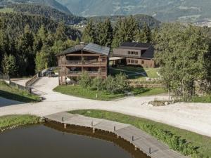 an aerial view of a house with a lake at Arieshof Castell in San Lorenzo di Sebato
