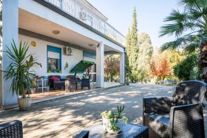 un patio con sillas y mesas frente a una casa en Valateddi, en Cammarata