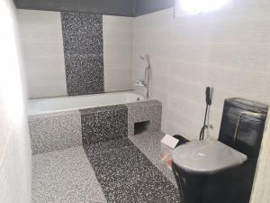 a bathroom with a bath tub and a toilet at Villa de luxe Domaine Léna vue sur mer in Foulpointe +51 photos