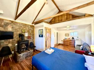 a bedroom with a blue bed and a living room at The Village Cabins in Big Bear Lake