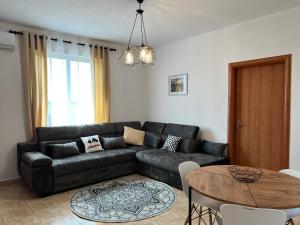 een woonkamer met een bank en een tafel bij Sergio Apartment in Durrës