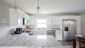 a kitchen with white cabinets and a stainless steel refrigerator at Park Place with space, 10 minutes to Ark in Dry Ridge