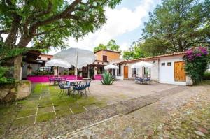 a patio with tables and chairs and umbrellas at Xani Mui in San Jerónimo Aculco