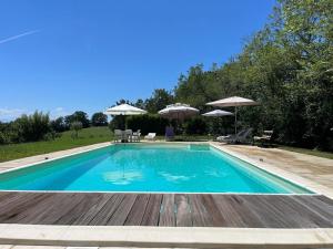 a swimming pool with chairs and umbrellas at Le Paradis Saint Frajou, very beautiful Villa 200m2 swimming pool and style in Saint-Frajou