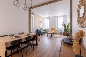 ein Wohnzimmer mit einem Tisch und Stühlen in der Unterkunft La Saint-Quentinoise chambre privée amande in Saint-Quentin